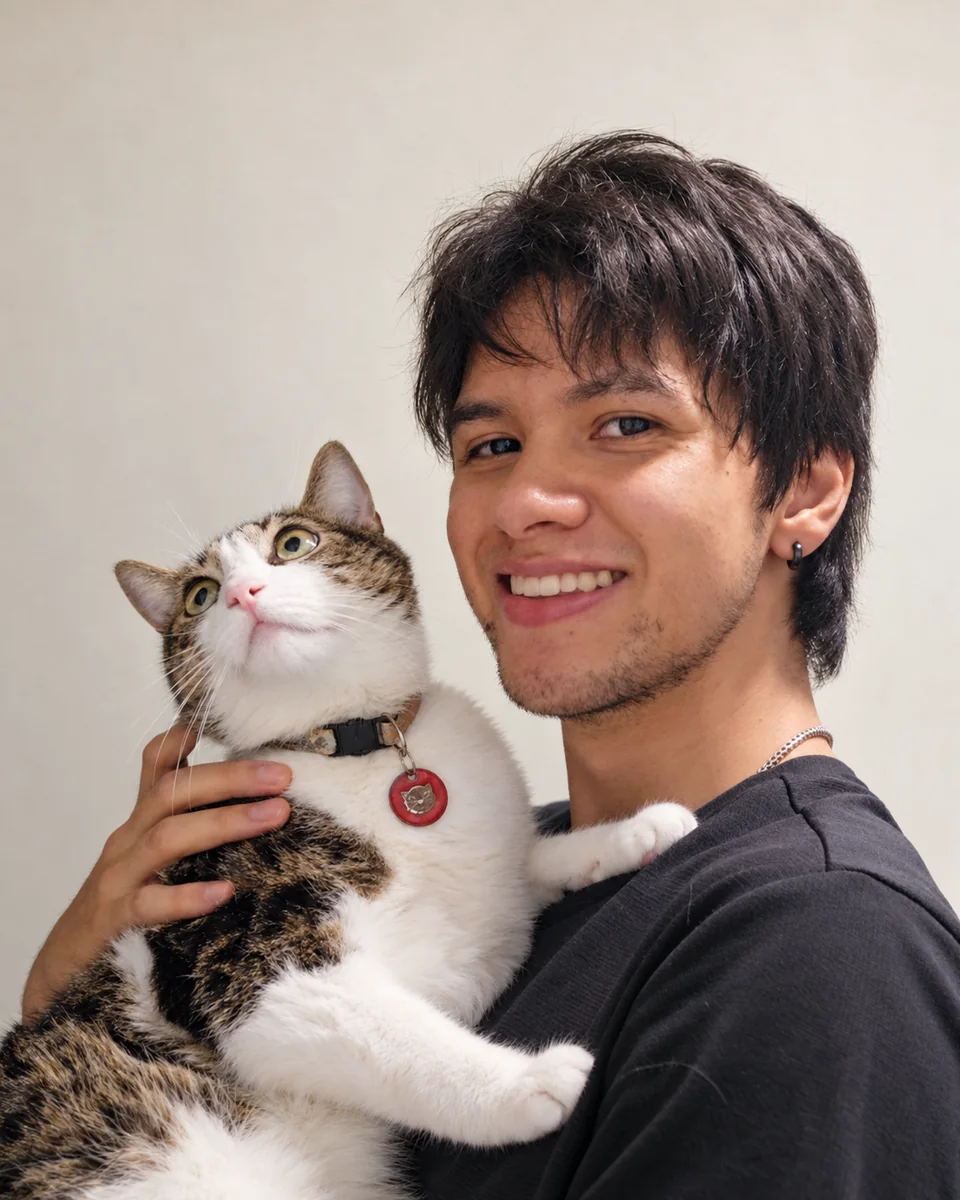 Santiago sonríe mientras sostiene a Ahru, su gato, en brazos.